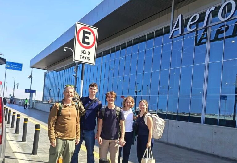 Five tourists with luggage arriving at the curbside entrance of the new Jorge Chávez International Airport in Lima, Peru