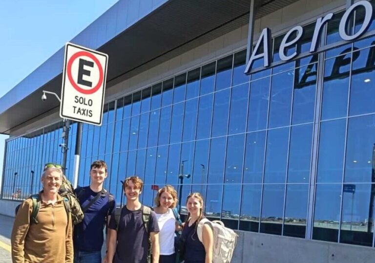 Five tourists with luggage arriving at the curbside entrance of the new Jorge Chávez International Airport in Lima, Peru