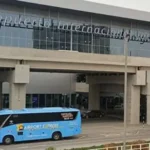 Exterior of the new Jorge Chávez Lima Airport terminal, featuring an Airport Express bus and a taxi at the pickup zone.